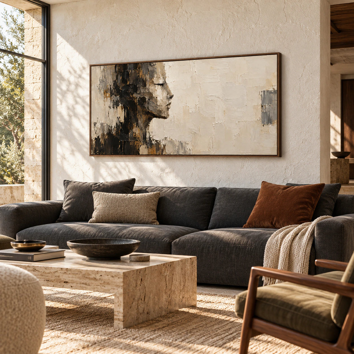 Shadow-Ledger above a low charcoal sofa on a pale stone wall, viewed from the left at seated eye level with daylight from a tall window.