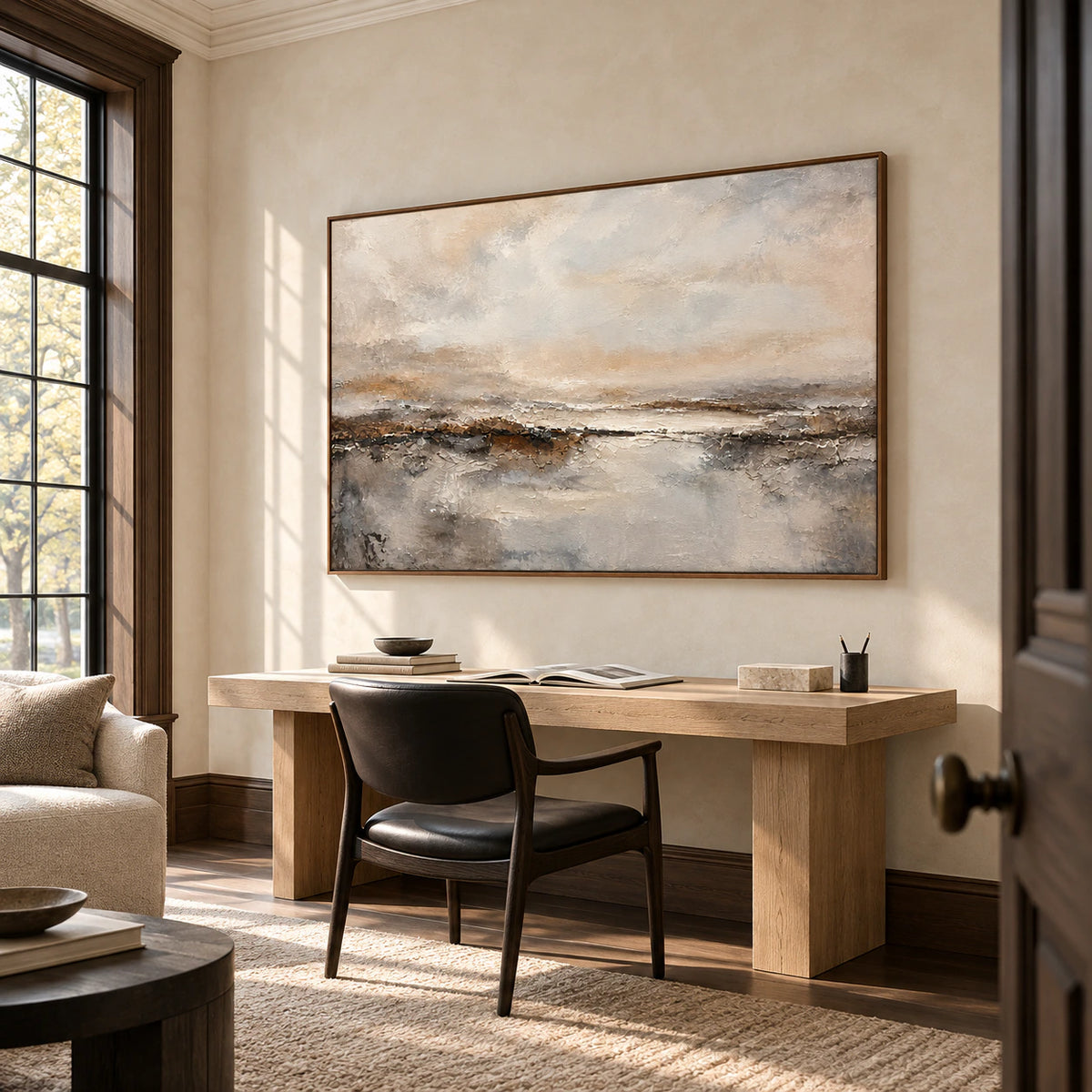 Large tactile abstract artwork above a light wood desk in an airy home office with soft daylight and uncluttered furnishings.