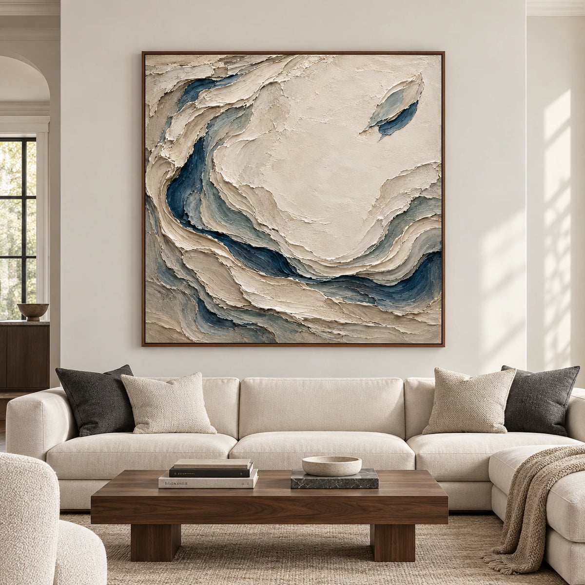 Large square Slate-Eddies artwork centered on a bright, spacious living room wall, its cream field and slate blue folds clearly visible.