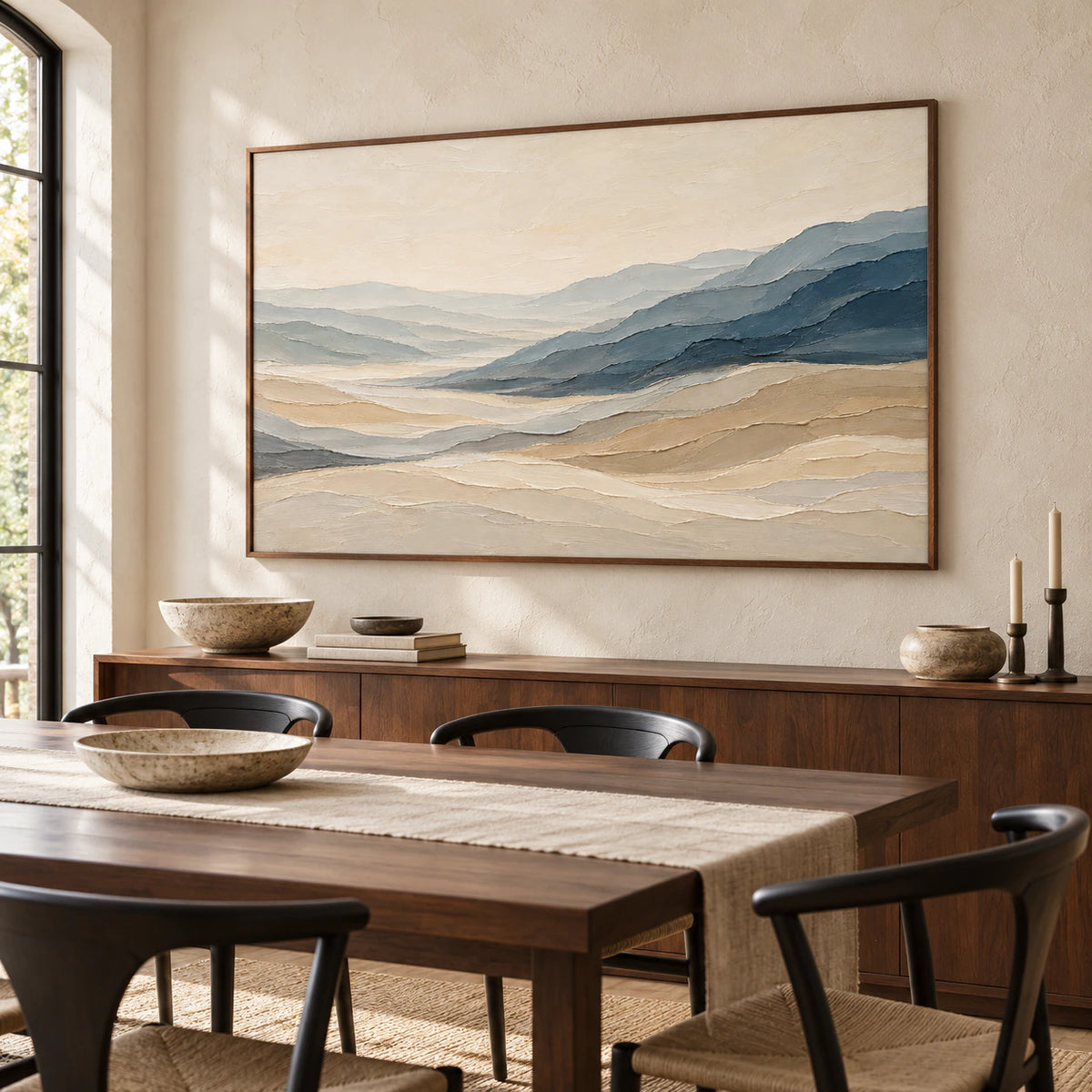 Textured slate-blue and sand landscape artwork anchoring a refined dining room with a long dark wood table.