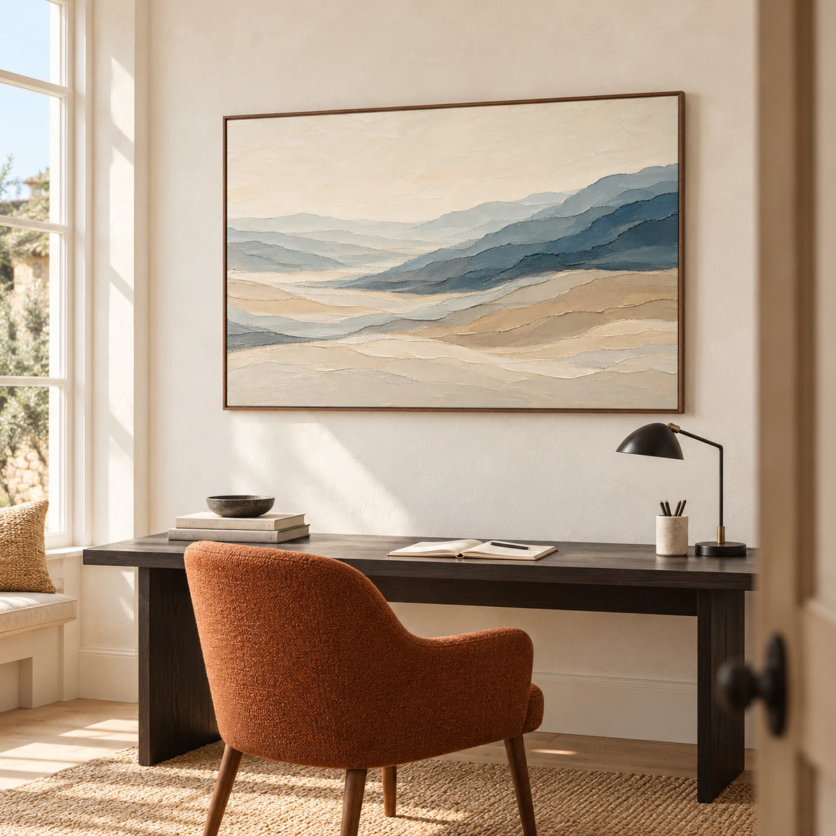 Large landscape artwork above a simple desk in an airy home office with restrained neutral furnishings.