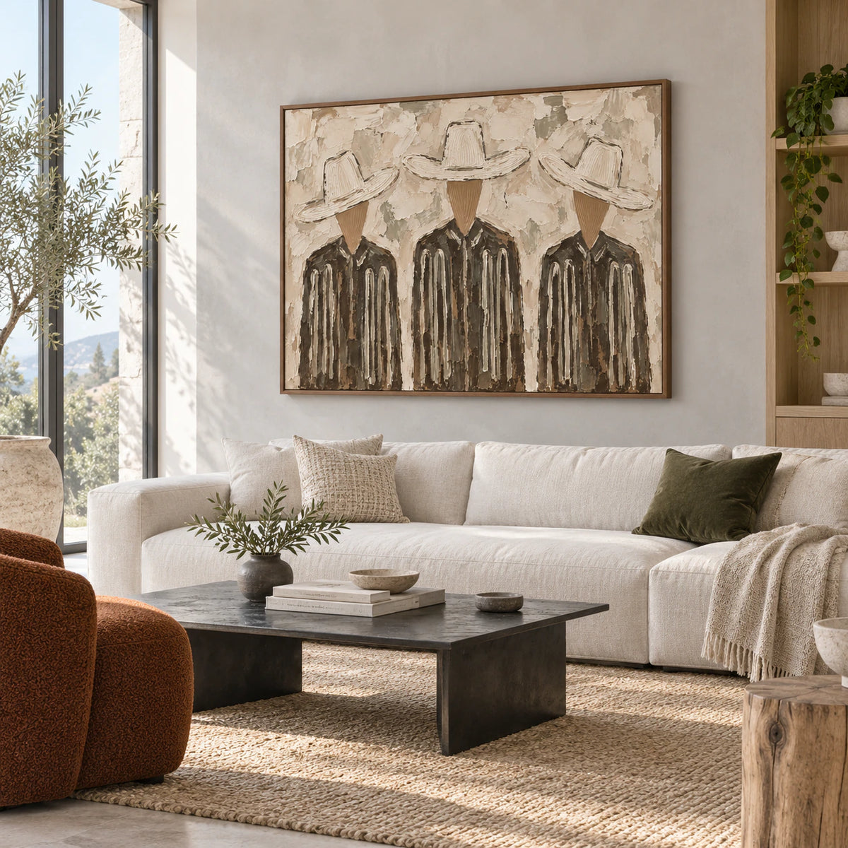 Textured three-figure painting above a sofa in a bright, restrained living room.