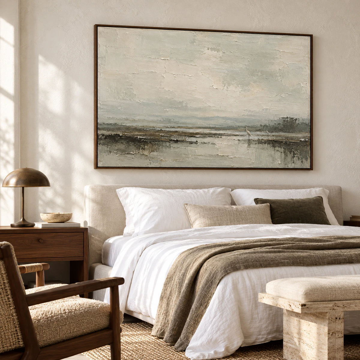 Horizontal marsh painting above a simple bed in a quiet daylight bedroom, showing its full pale sky, water, and two birds.