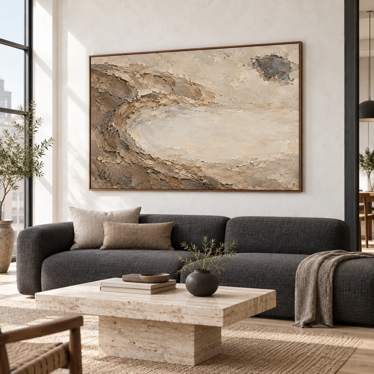 Horizontal textured abstract painting above a sofa in a bright living room.