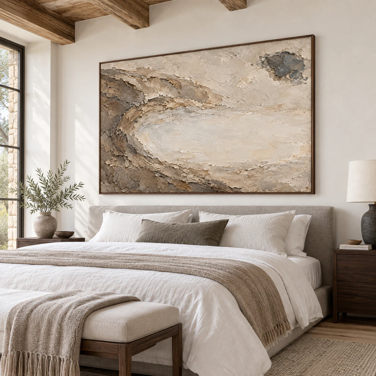Horizontal textured abstract painting above a quiet bedroom seating area.