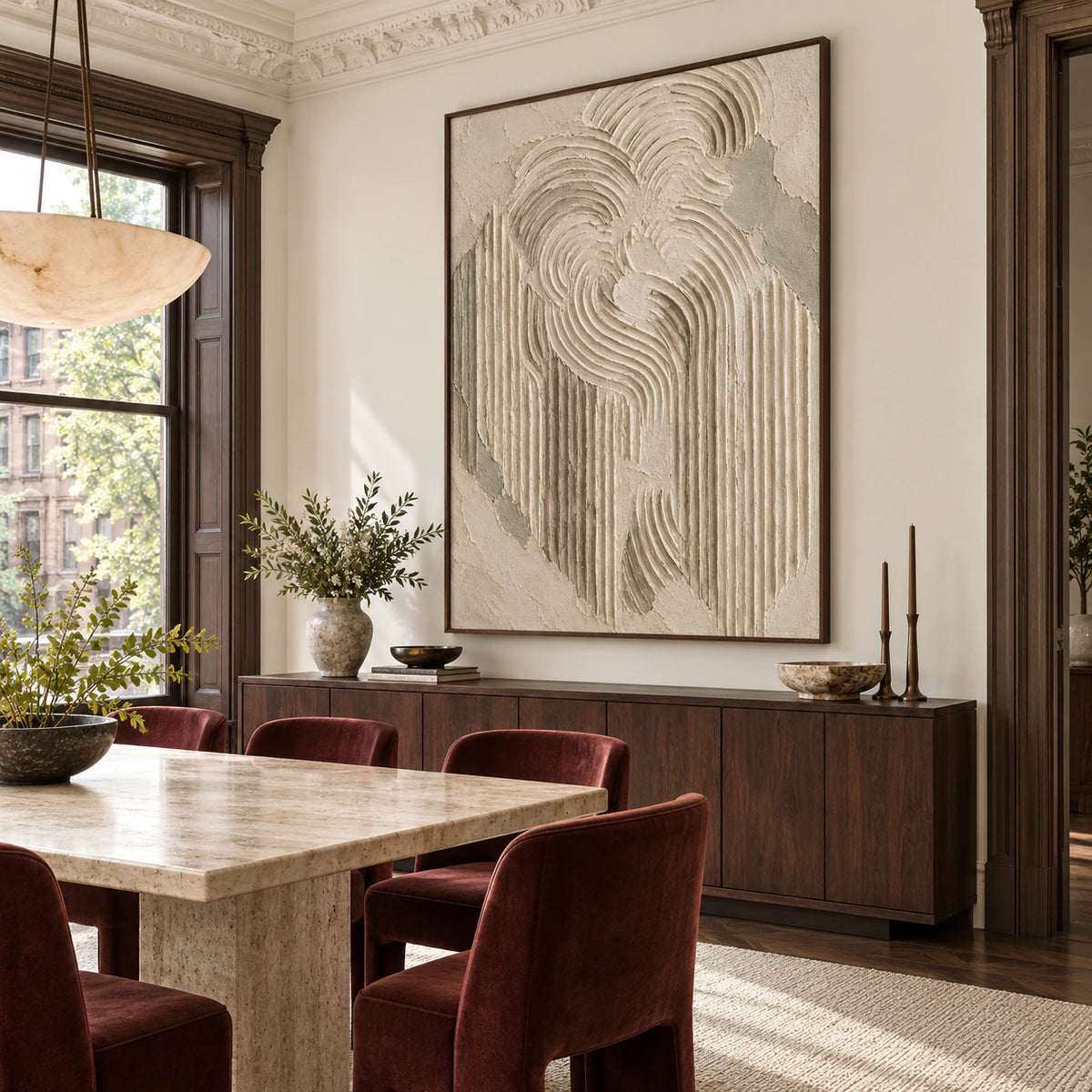 Large ivory and sage-grey relief artwork in a refined daylight-filled dining room.