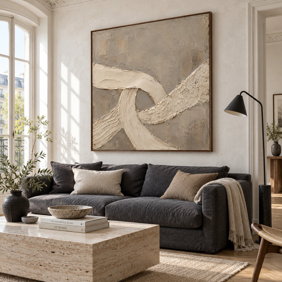 Square textured abstract artwork above a sofa in a bright living room.