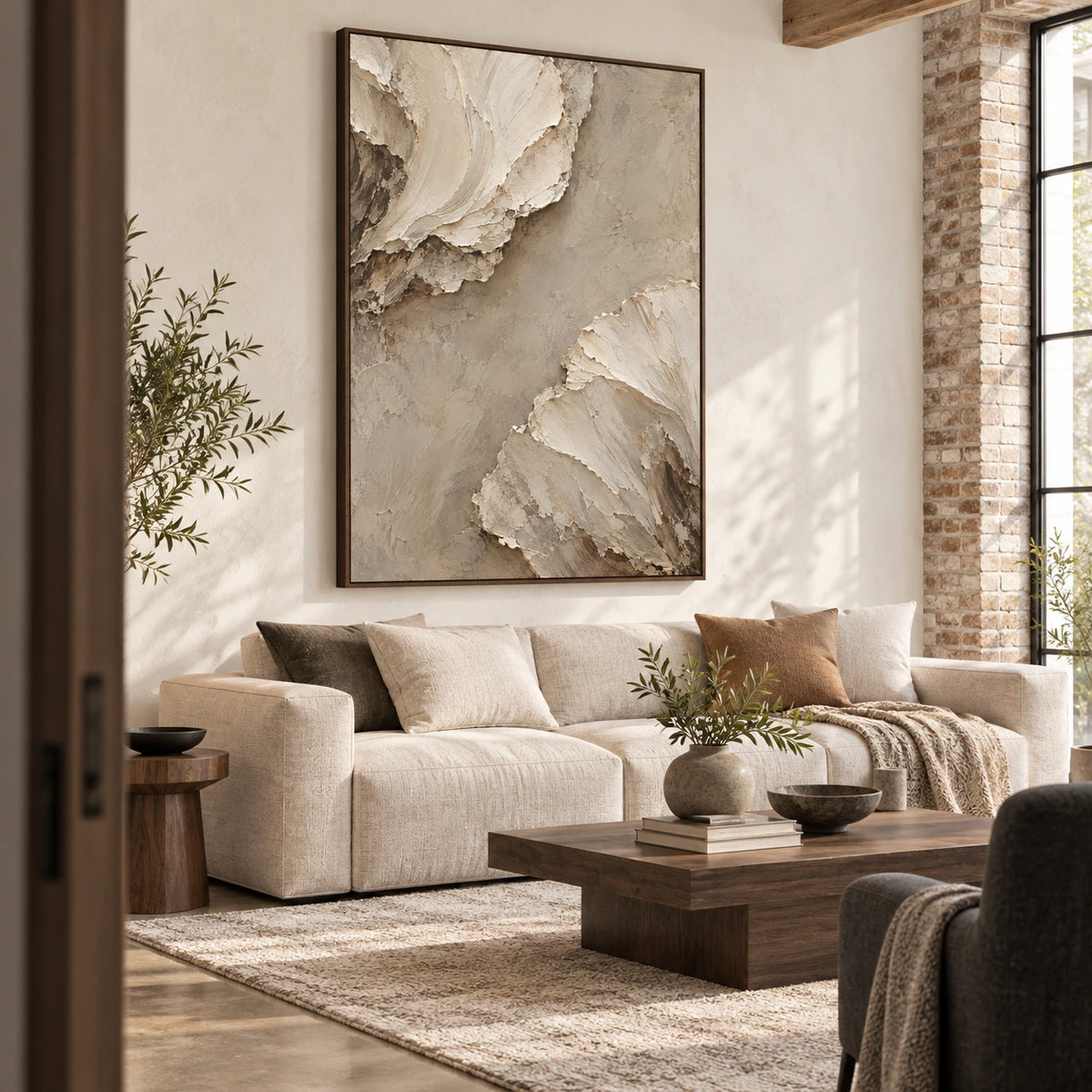 Textured ivory and sand abstract painting above a sofa in a bright living room.