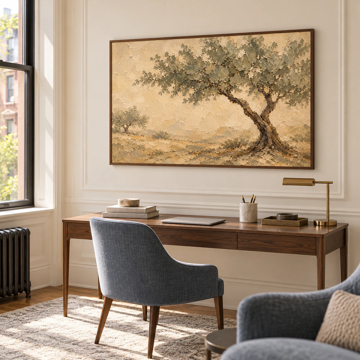 Ochre landscape painting featured above a simple desk in an airy home office with natural light.