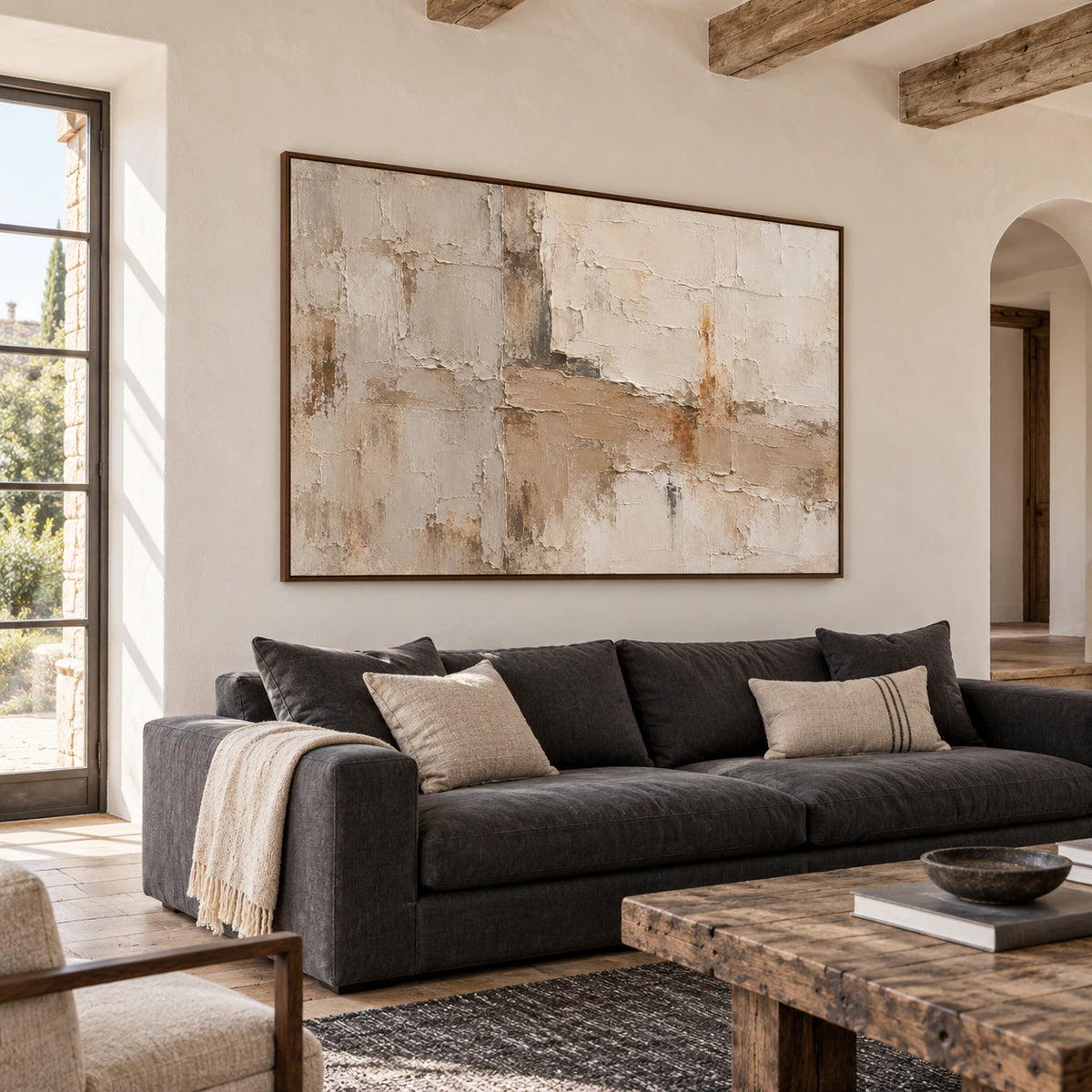 Large textured abstract artwork above a restrained sofa in a bright living room.
