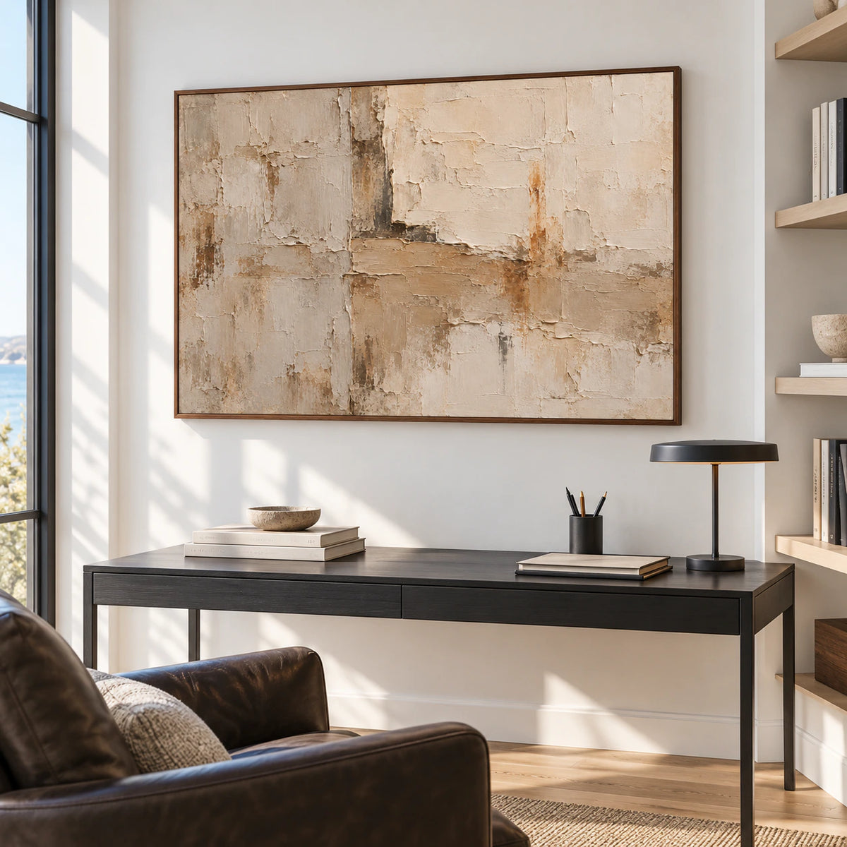 Large abstract artwork in an airy home office and reading space with a desk and lounge chair.