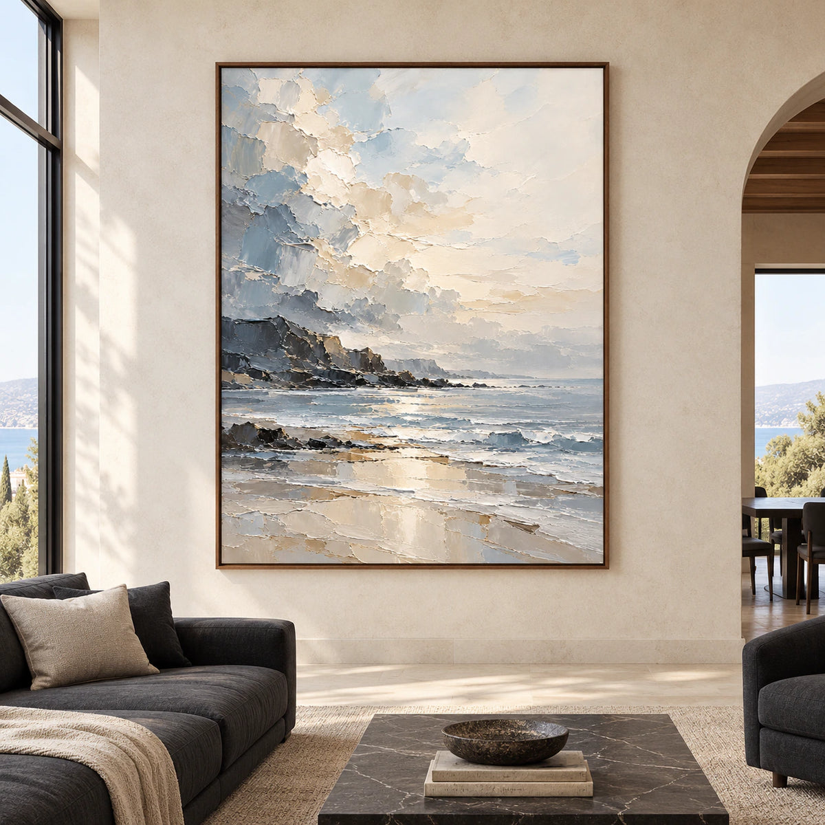 Large vertical coastal painting viewed straight-on in a bright modern living room with pale stone walls, restrained dark furnishings and natural daylight.
