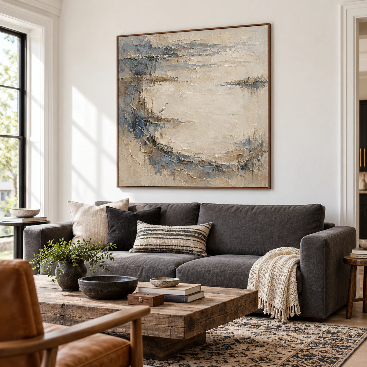 Large Tidal Heron artwork above a low sofa in a bright living room with restrained neutral furnishings.