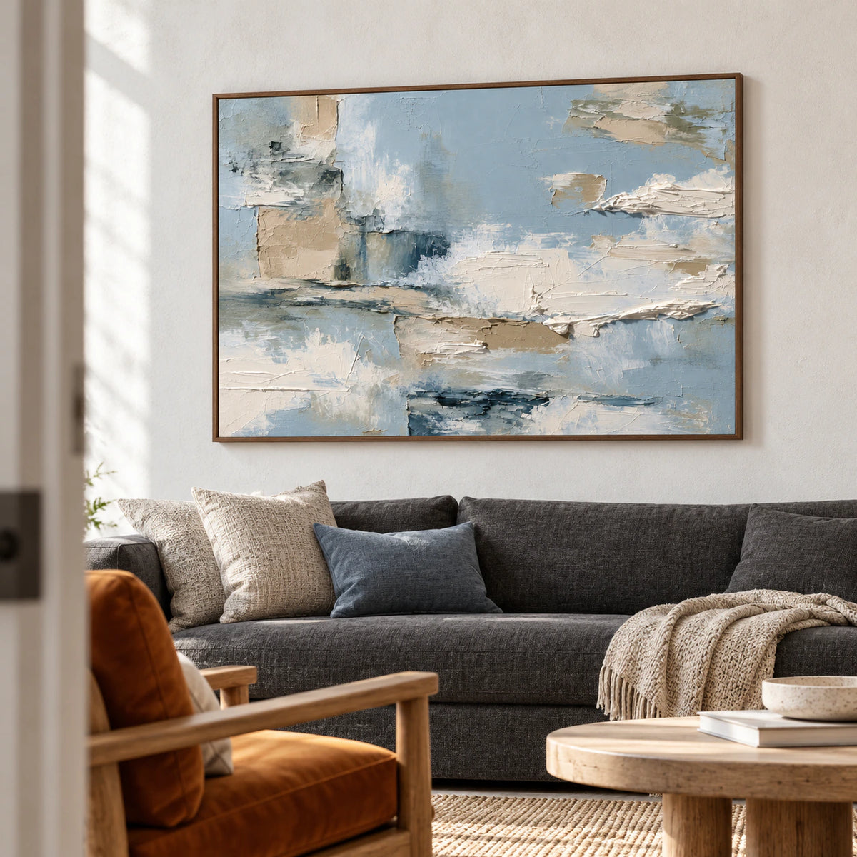 Tidal-Mantle in a bright living room with a charcoal sofa, warm wood details and pale plaster walls, viewed from a slight left angle.