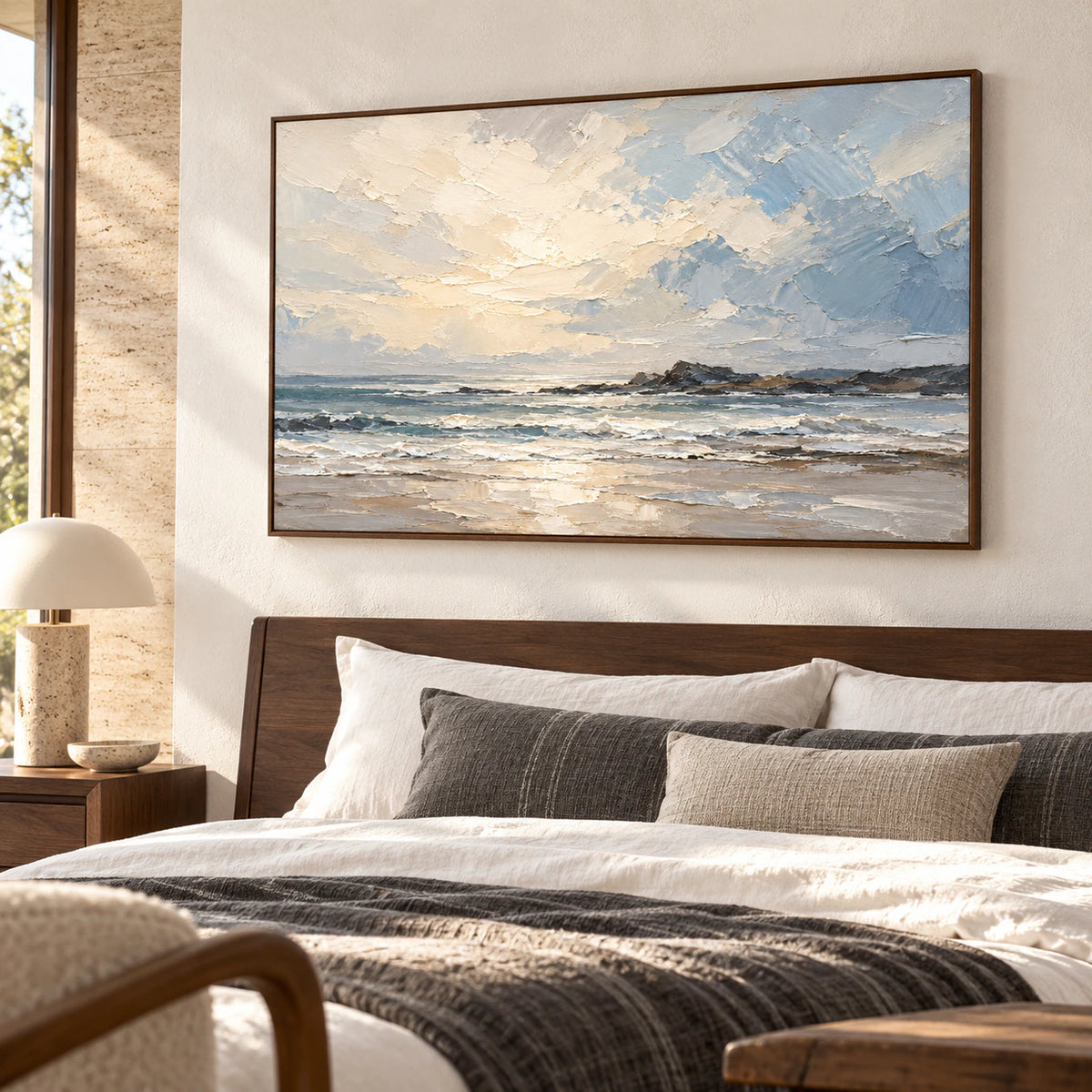 Large seascape painting above a dark wood bed with white and muted charcoal textiles, viewed from a low left angle in soft morning light.