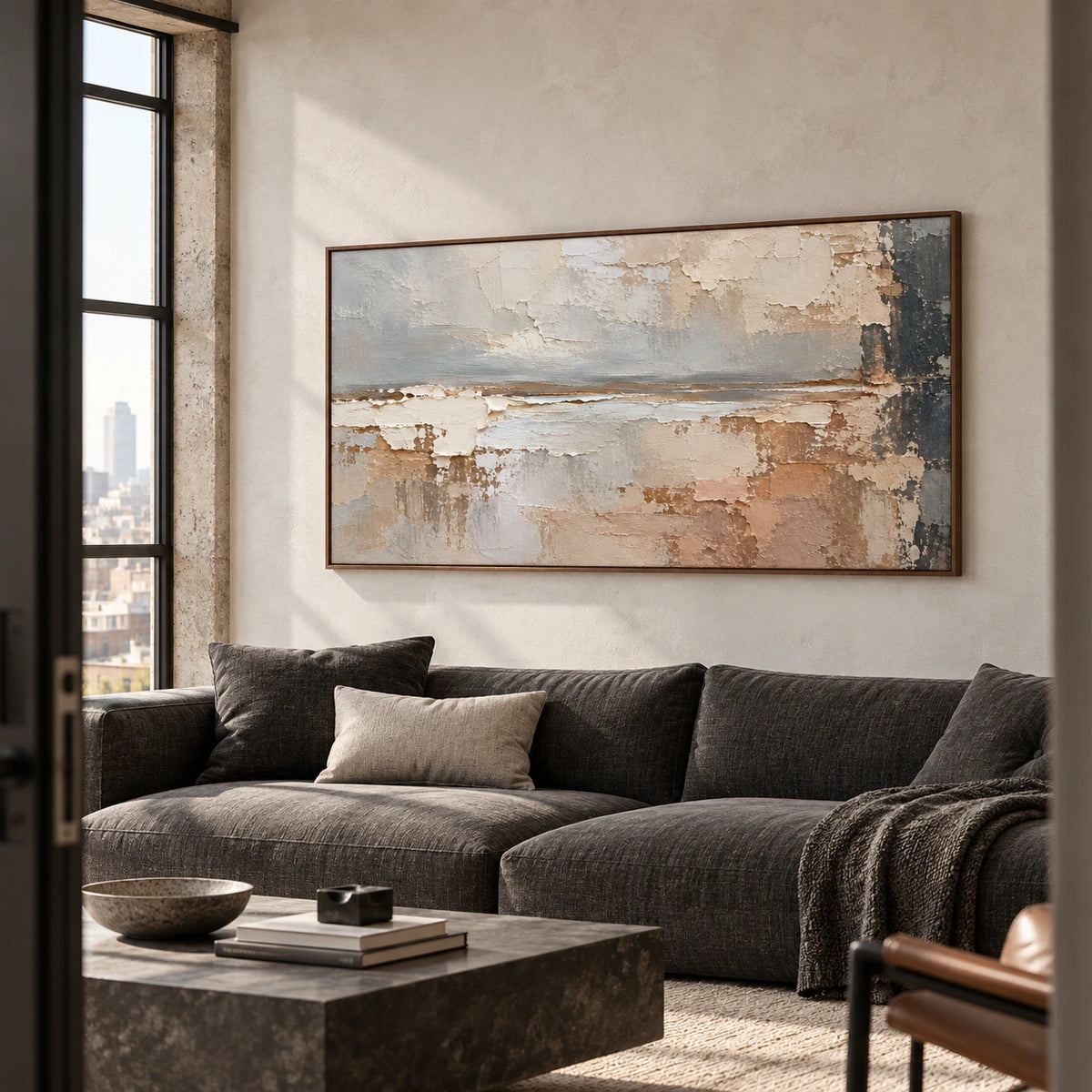 Large horizontal abstract painting above a charcoal sofa in a bright living room with pale walls, viewed from a left oblique angle.