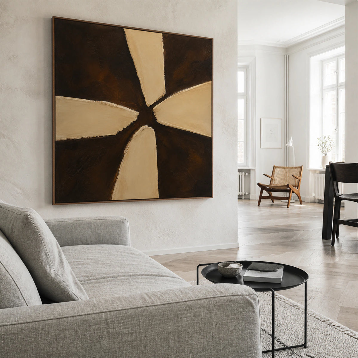Square umber and ochre abstract painting above a bright living room seating arrangement.