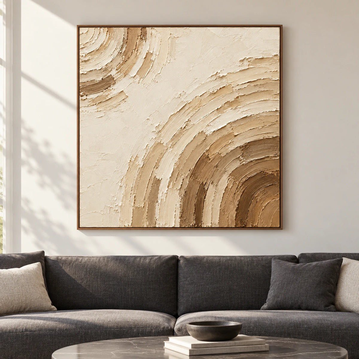 Large square ivory and umber abstract painting viewed straight-on in a spacious contemporary room with pale walls, charcoal furniture and bright daylight.