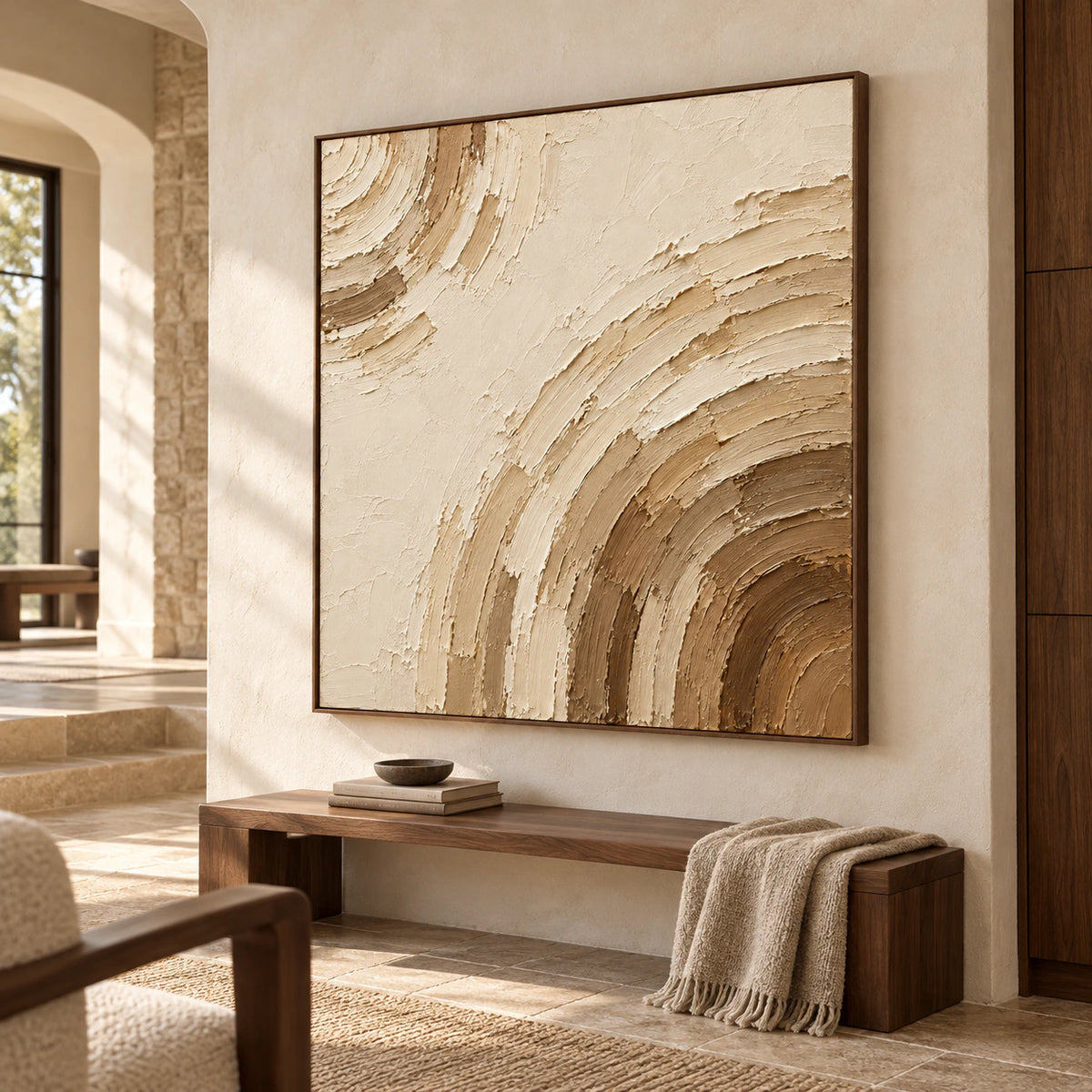 Large square ivory and umber abstract painting on tall pale stone walls in a foyer with dark wood bench seating, viewed from a slightly low left angle.