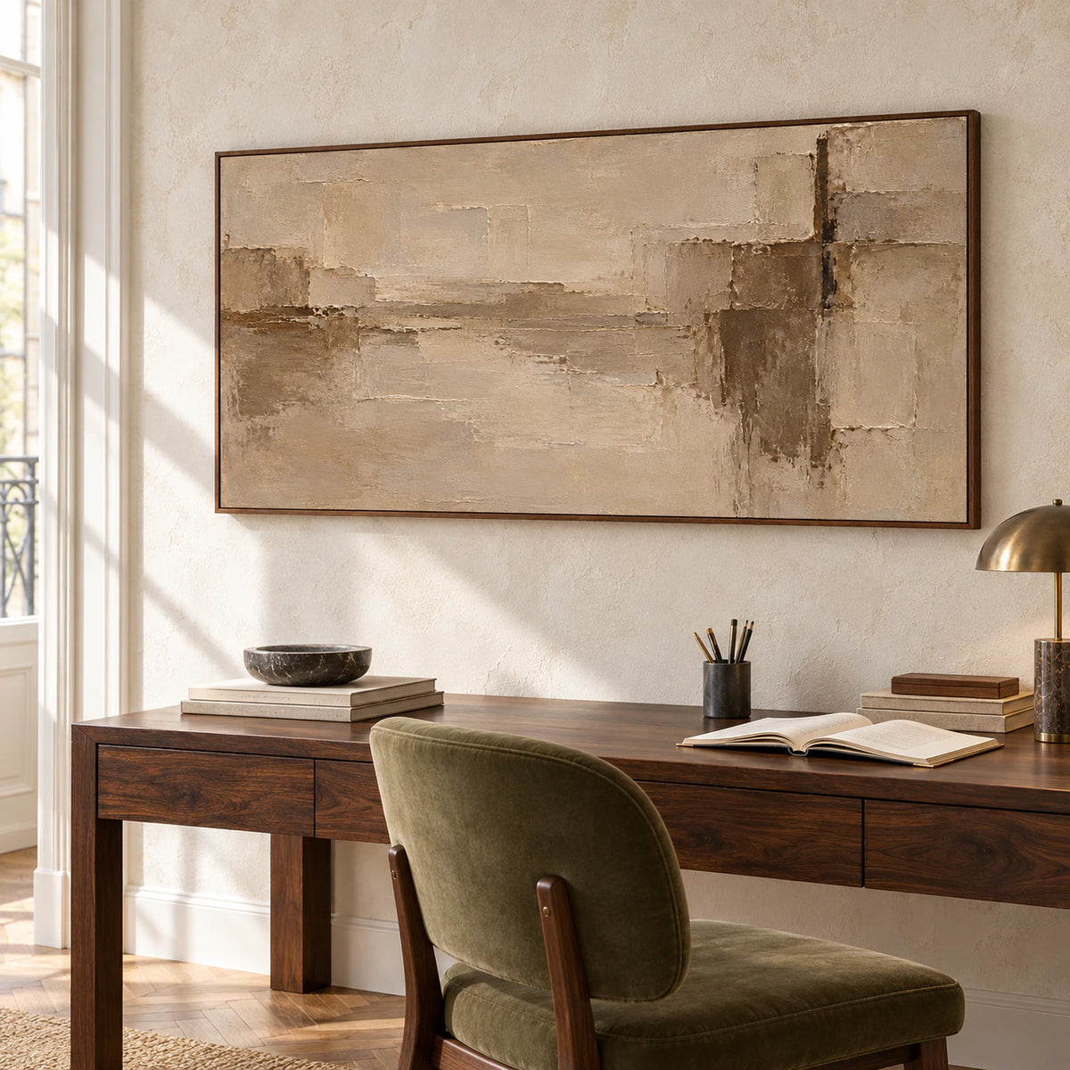 Wide textured abstract painting above a dark walnut desk beside an olive chair in a bright home office, viewed from the right.
