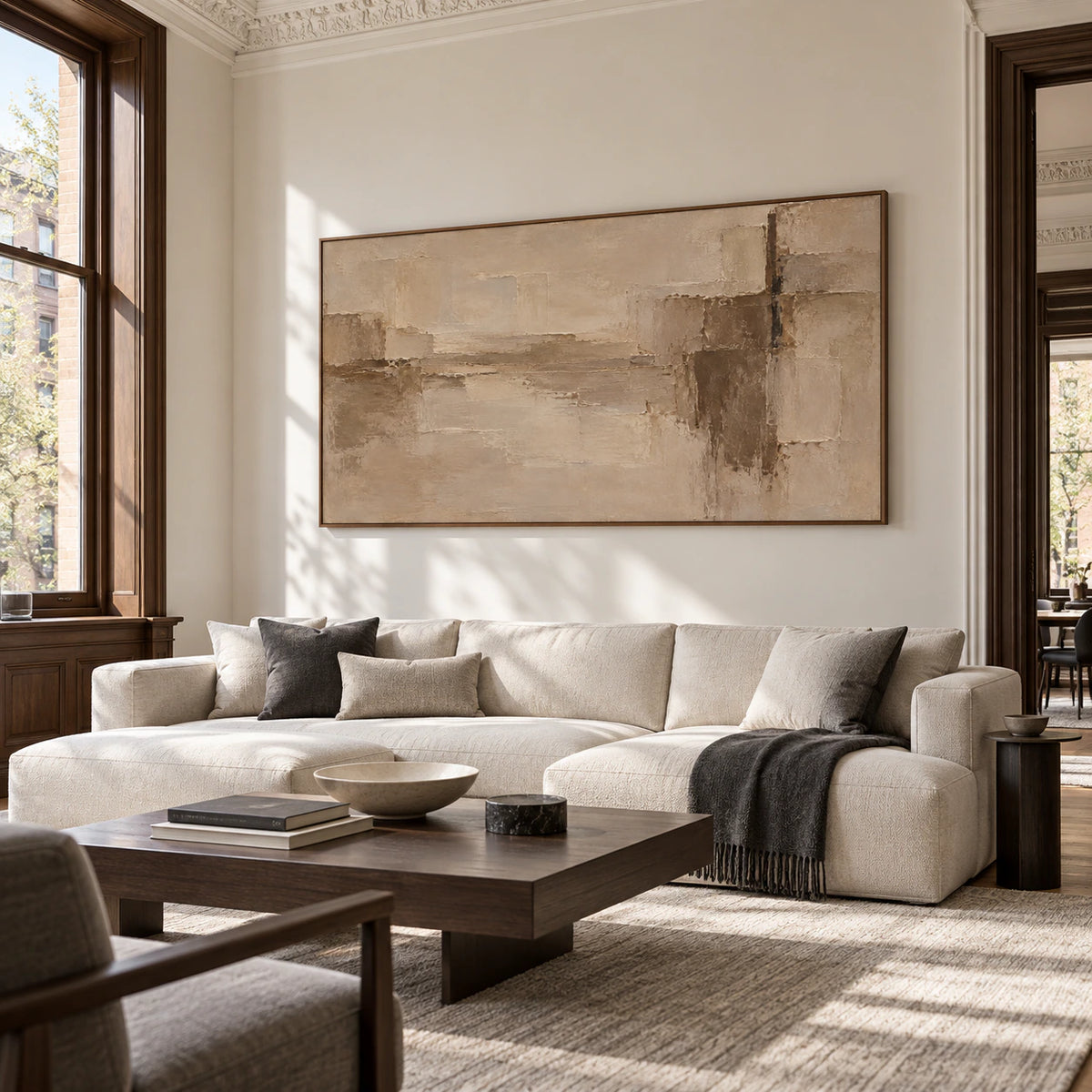 Wide textured abstract painting on a high wall in an expansive loft with graphite and ivory furnishings and bright daylight, viewed from the right.