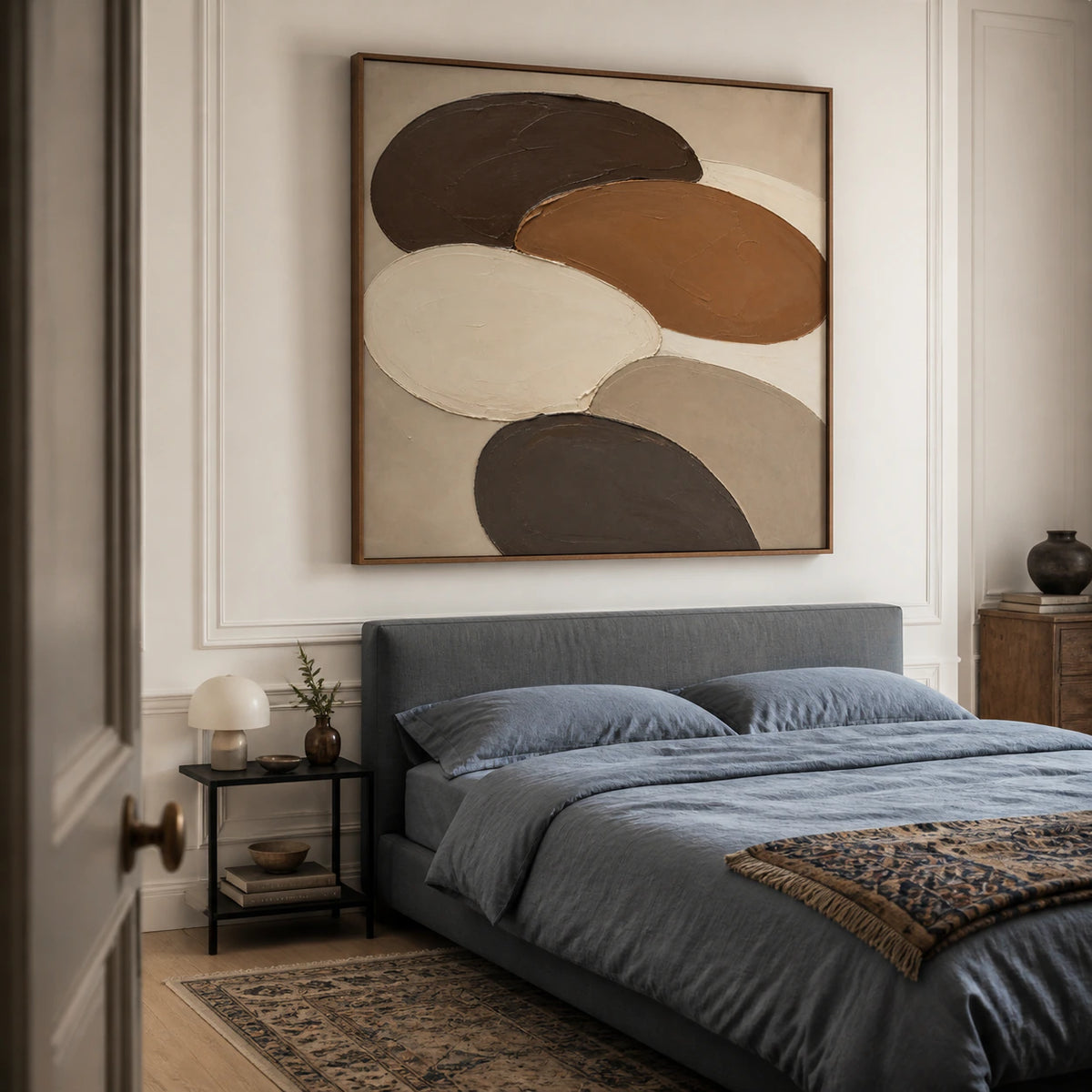 Textured square Umber-Orbits painting in a quiet, light-filled bedroom.