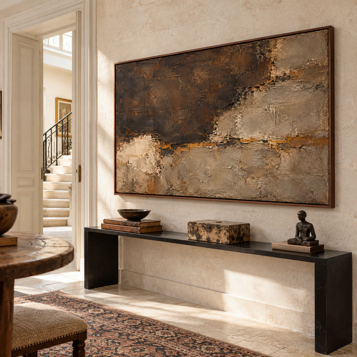 Large horizontal abstract painting commanding the wall of a bright, high-ceilinged foyer with a stone console below.