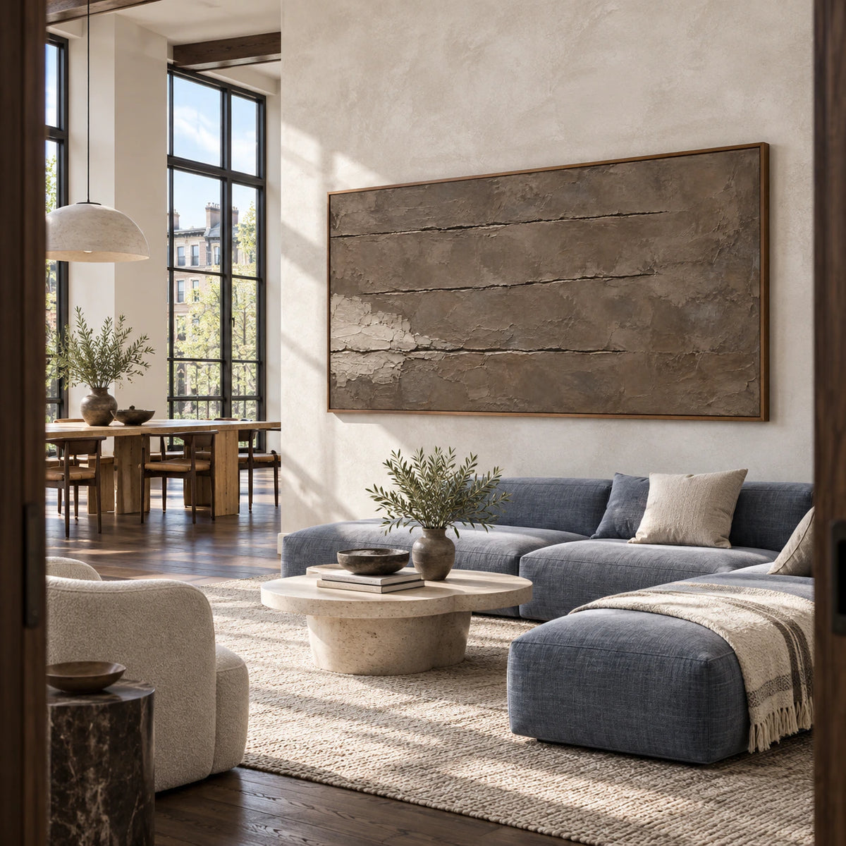 Large panoramic textured abstract artwork in an open hospitality loft interior.