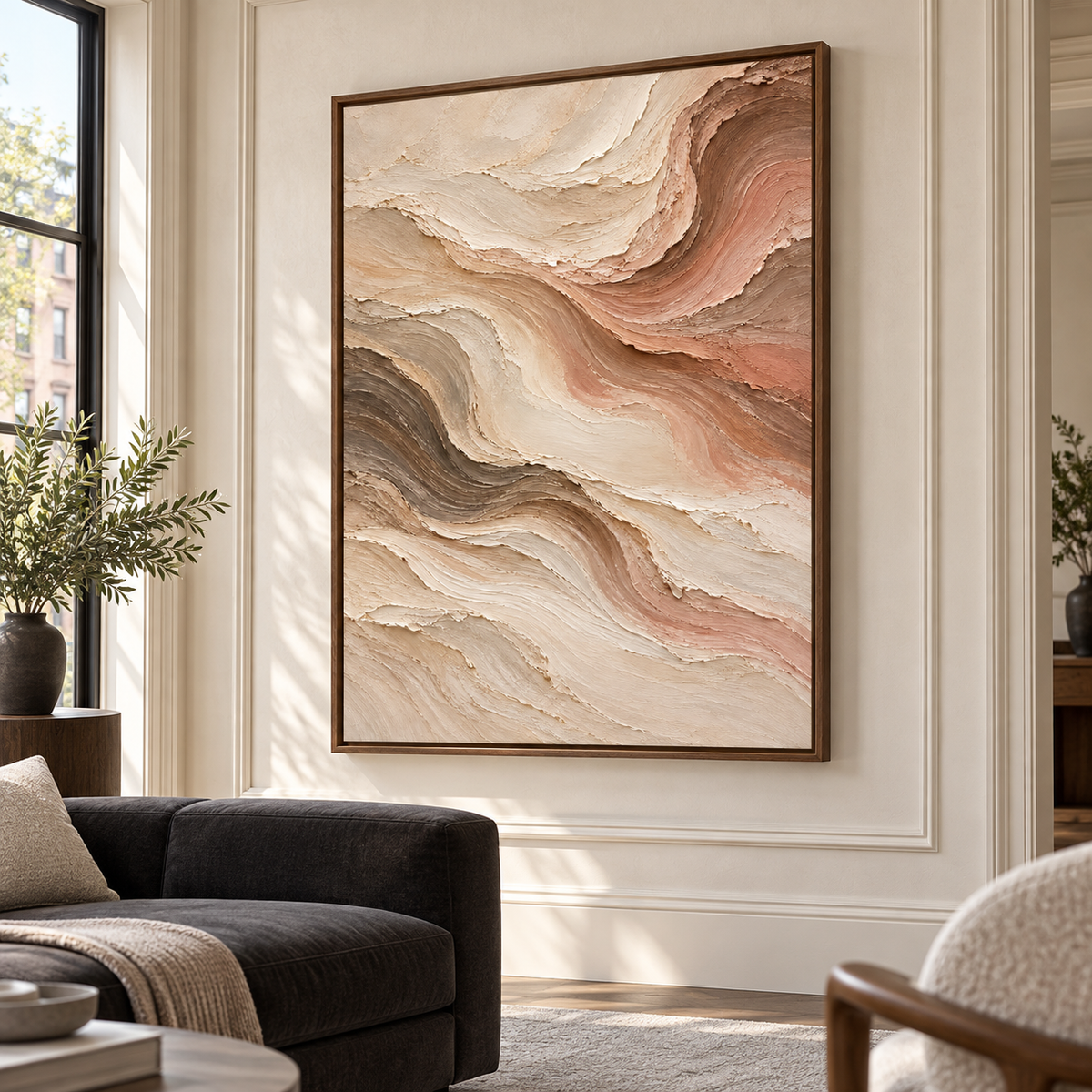 Vertical abstract painting with ivory, taupe, rose and brown ridges above a charcoal sofa on a pale limewashed wall, viewed from the left in a sunlit living room.