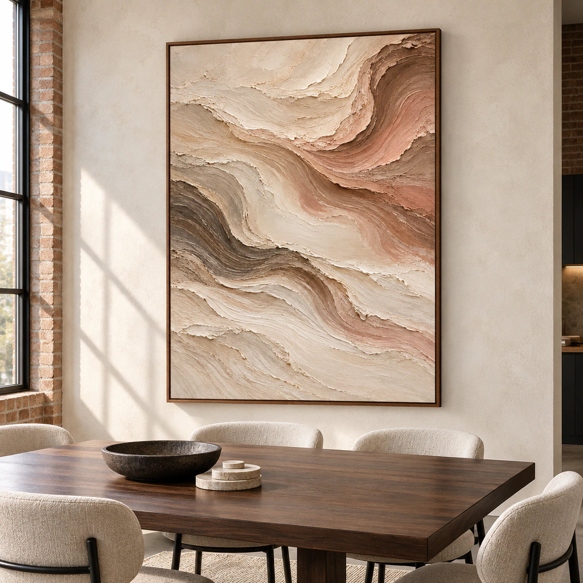 Vertical abstract painting with flowing warm-toned ridges above a dark walnut dining table with pale chairs, viewed from a gentle right angle in daylight.