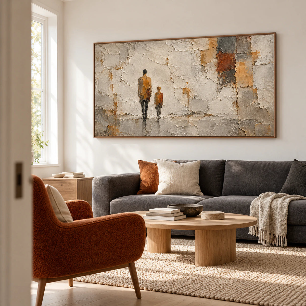Large painting of two ochre figures against broken ivory plaster above a restrained charcoal sofa in a bright, open living room.